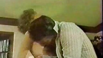 O fată cu părul negru își pune buzele pe un stâlp lung și dur pentru a suge